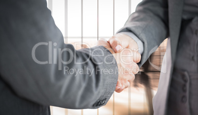 Composite image of business people shaking hands close up