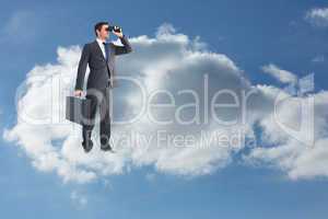 Composite image of businessman looking through binoculars