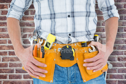 Composite image of cropped image of technician with tool belt ar