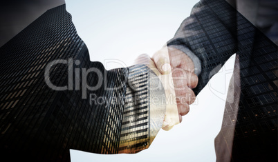 Composite image of business people shaking hands close up
