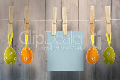 Composite image of hanging easter eggs and card