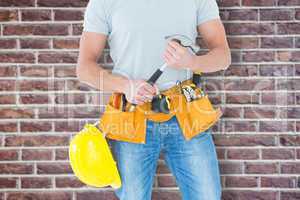 Composite image of worker holding hammer over white background