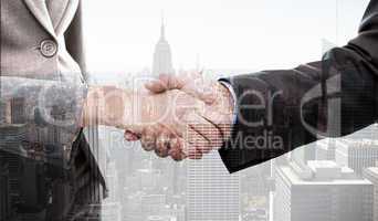 Composite image of close up of two businesspeople shaking their