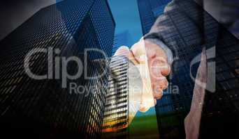 Composite image of business people shaking hands close up