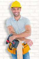 Composite image of smiling male carpenter with power drill and p