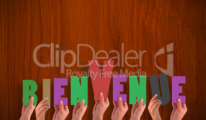 Composite image of hands holding up bienvenue