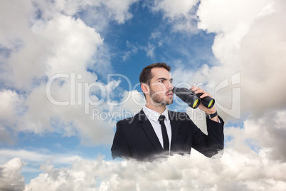 Composite image of surprised businessman standing and holding bi