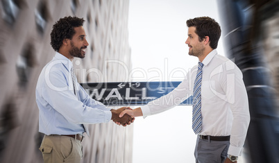 Composite image of smiling young businessmen shaking hands in of