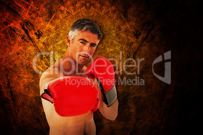 Composite image of fit man punching with boxing gloves
