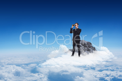 Composite image of elegant businessman standing and using binocu