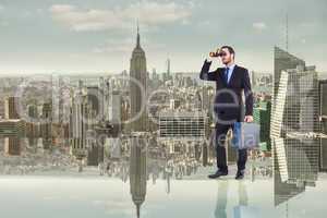 Composite image of businessman looking through binoculars holdin