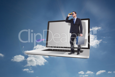 Composite image of businessman looking through binoculars holdin