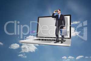 Composite image of businessman looking through binoculars holdin