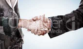 Composite image of close up of two businesspeople shaking their