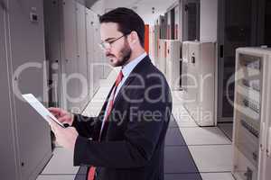 Composite image of businessman scrolling on his digital tablet