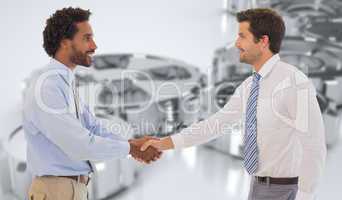 Composite image of smiling young businessmen shaking hands in of