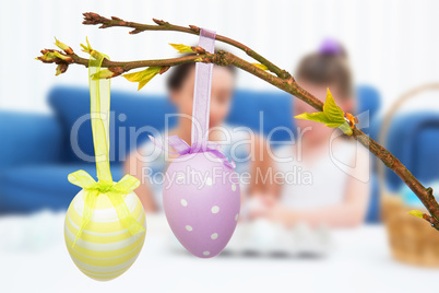 Composite image of mother and daughter painting easter eggs