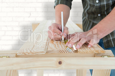 Composite image of carpenter marking on wooden plank