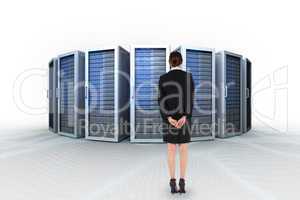 Composite image of young businesswoman standing with hands behin