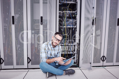 Composite image of handsome hipster using tablet pc