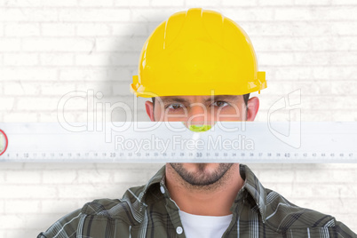 Composite image of handyman looking at spirit level