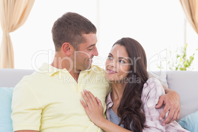 Couple looking at each other on sofa at home