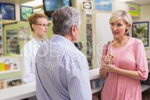 Pharmacist and her customers talking about medication