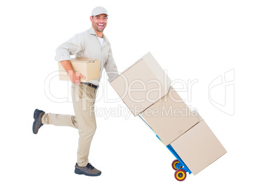 Happy delivery man with trolley of boxes running on white backgr