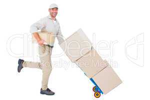 Happy delivery man with trolley of boxes running on white backgr