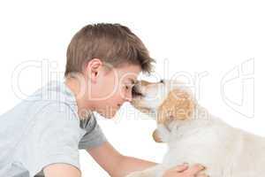 Puppy licking boy over white background