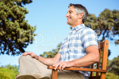 Casual man relaxing on park bench