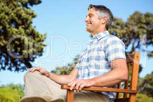 Casual man relaxing on park bench