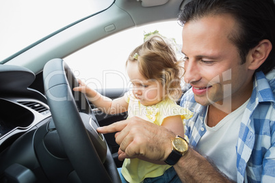 Father playing with baby in drivers seat