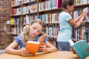 Cute pupils reading in library