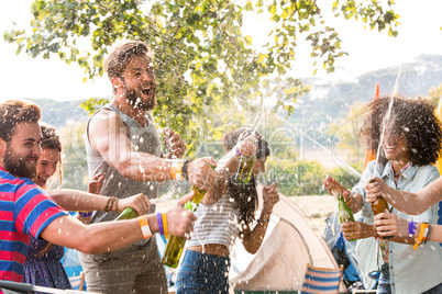 Hipsters spraying beer over each other