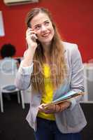 Casual businesswoman using cellphone in office