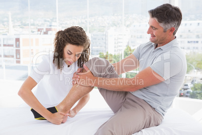 Doctor putting ankle brace to her patient