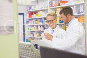Senior pharmacist reading a prescription on clipboard