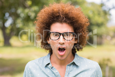 Young man looking surprised in the park