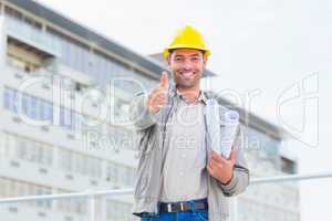 Architect with blueprints gesturing thumbs up outdoors