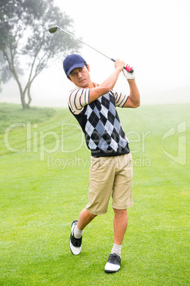 Golfer teeing off