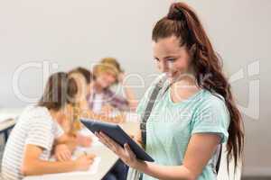 Female student using digital tablet in classroom
