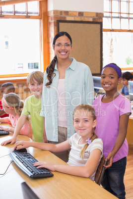 Cute pupils in computer class with teacher