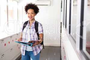 Smiling young woman with folder in office