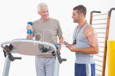 Senior man on treadmill with trainer