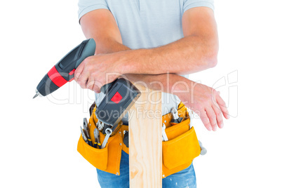 Midsection of male carpenter with power drill and plank