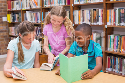 Cute pupils reading in library