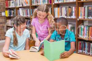 Cute pupils reading in library