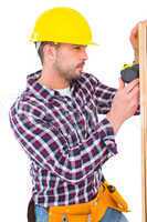 Handyman using measure tape on wooden plank