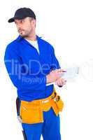 Handyman in blue overall writing on clipboard